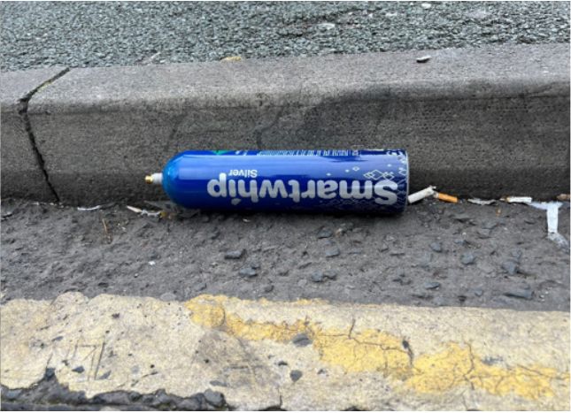 Duża puszka po tlenku azotu z wyraźnie 'rekreacyjnym' designem na ulicy